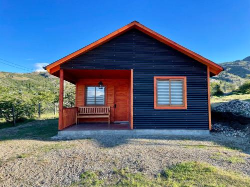 a small cabin with a bench in front of it at Cabaña Canelita in Cochrane