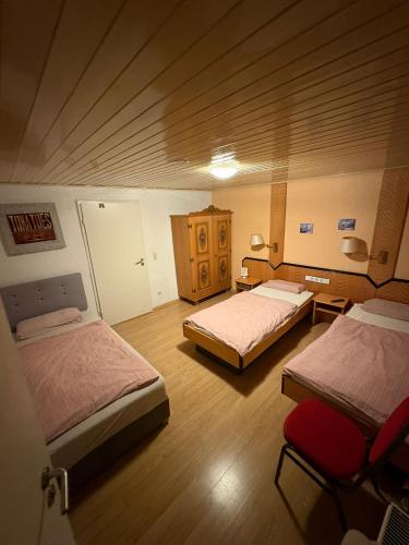 une chambre avec deux lits et un parquet dans l'établissement Cin Pension, à Gronau