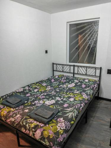 a bedroom with a bed with a floral bedspread at Studio Dimon in Pleven