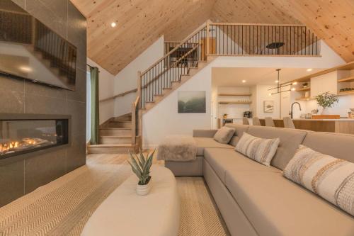 un soggiorno con divano e camino di Kos - Domaine du Grand Portneuf - Spa Nature & Comfort a Pont-Rouge