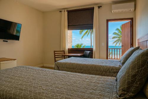 ein Schlafzimmer mit zwei Betten und Meerblick in der Unterkunft Senses Praia Hotel in Guarujá