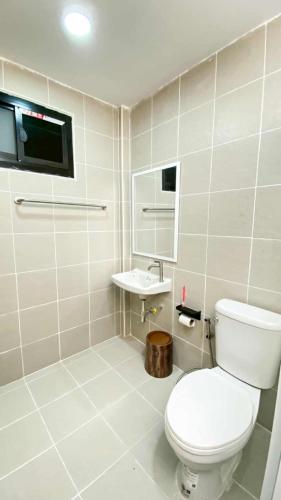 a white bathroom with a toilet and a sink at Wasana Village Phutoei in Ban Phu Toei