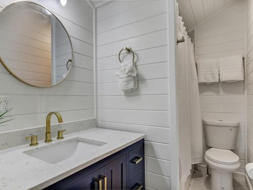 a white bathroom with a sink and a mirror at Beachside Villa Unit 5 in Tybee Island