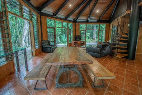 a large wooden table in the middle of a living room at Daintree Cascades in Cape Tribulation