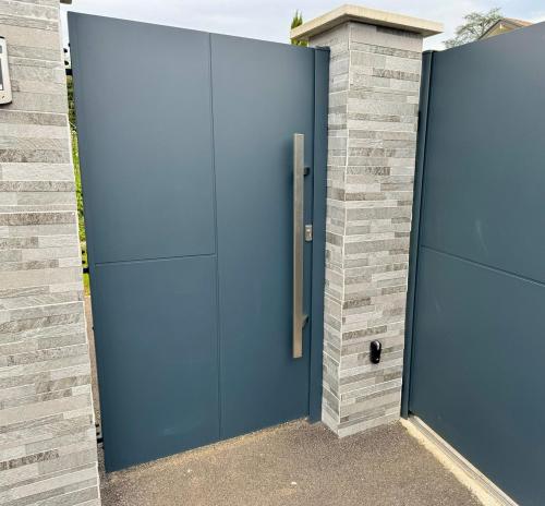 una porta blu sul lato di un edificio in mattoni di Cosy studio Noha a Thonon-les-Bains