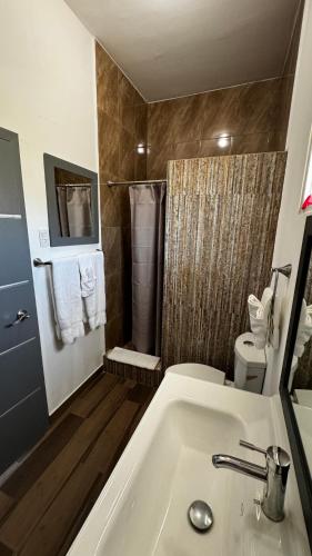 a bathroom with a white sink and a shower at Hotel Cuatro Palmas in Puerto Peñasco