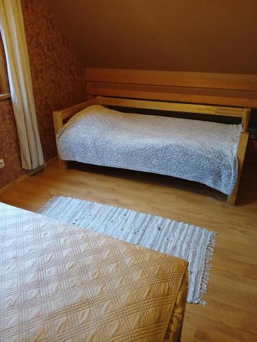 a bedroom with two beds and a rug at Pirts māja Lilijas in Baldone