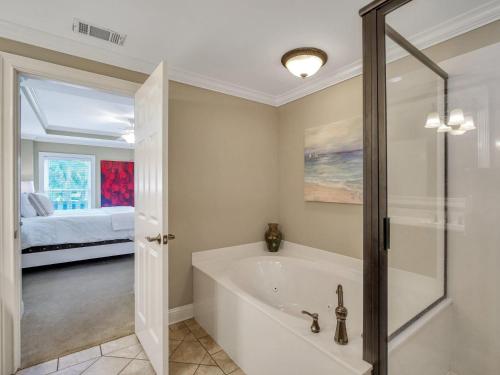 a bathroom with a bath tub and a bedroom at Silver Seas 103 in Tybee Island