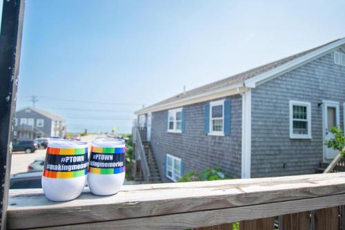 deux tasses à café colorées posées sur une balustrade en bois dans l'établissement East End Condo Across from Assoc Beach, à Provincetown