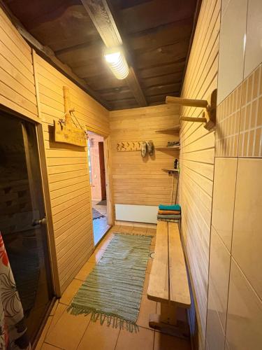 an empty room with a bench and a rug at Pirts māja Lilijas in Baldone