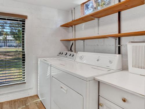 una cucina con elettrodomestici bianchi e una finestra di Ebb & Flow Apartment House a Tybee Island