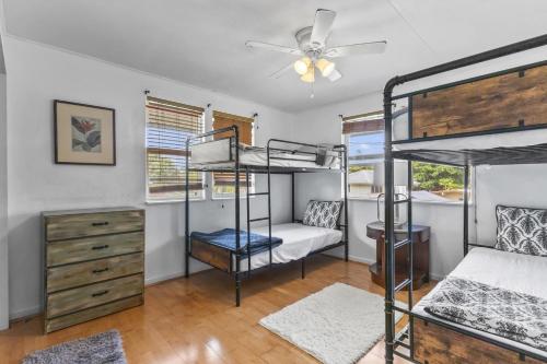 a bedroom with two bunk beds and a ceiling fan at Hale Kulamanu in Hauula