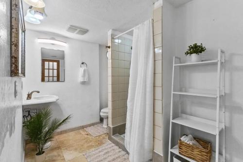 a white bathroom with a shower and a sink at Hale Kulamanu in Hauula