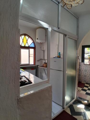 a kitchen with a refrigerator and a window at Arch Guesthouse - Dorm for Budget Travelers in Tangier in Tangier