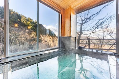 an indoor pool in a house with large windows at Noёl HAKONE GENSEN in Hakone
