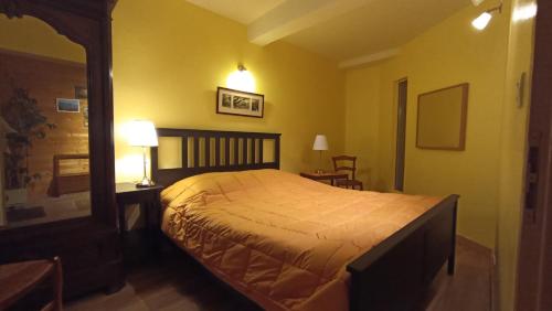 a bedroom with a large bed in a yellow room at Terra Médiane in Serres-sur-Arget