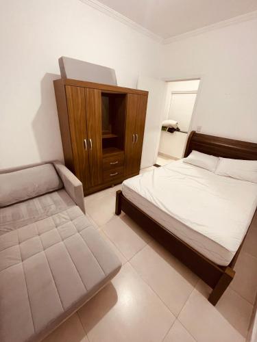a bedroom with a bed and a cabinet in it at Sobrado invertido 2 Quartos in Atibaia