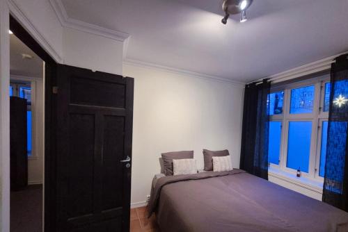 une chambre avec un lit et une grande fenêtre dans l'établissement Cozy 2BD apartment in Central Bergen, à Bergen