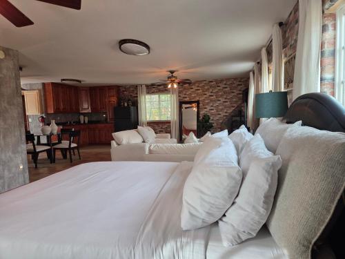 Una cama grande con almohadas blancas en una habitación. en Quaint Little Studio, en Apple Valley