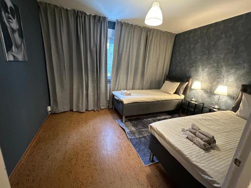 ein kleines Zimmer mit zwei Betten und einem Fenster in der Unterkunft Noah Longstay Bygatan in Västerås