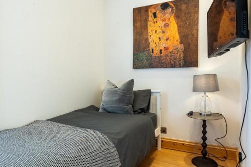 贝克斯利Bright & Comfy Single Room in Bexley Village的卧室里有一张床，墙上挂着一幅画