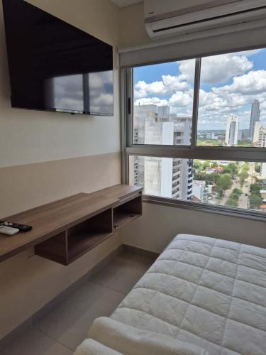Un dormitorio con una cama y una ventana grande. en Molas Tower 114B, en Asunción
