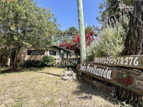 un panneau en bois devant une maison dans l'établissement Punta Avellaneda, à Punta del Diablo