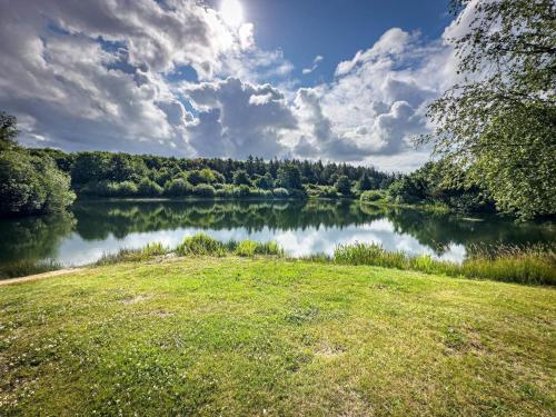 a view of a river with a grass field and clouds at 7 person holiday home in Toftlund in Vestergård