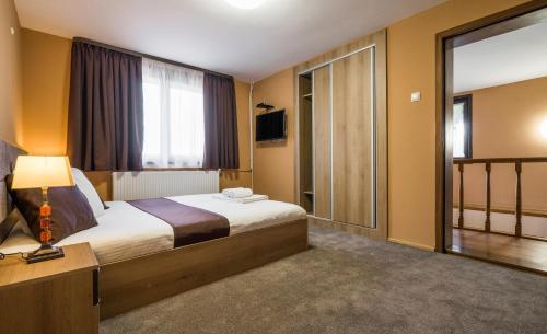 um quarto de hotel com uma cama e uma grande janela em Guest House Intrigue em Cherven