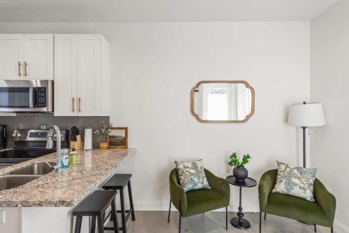 a kitchen with a counter and some green chairs at Charming Townhome - New Construction in Lafayette