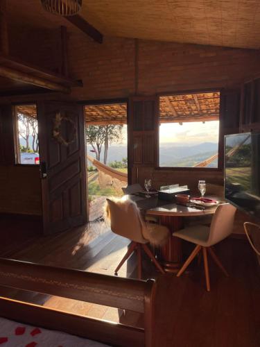 una sala da pranzo con tavolo e sedie in treno di Chalé Mirante da Serra a Sabará