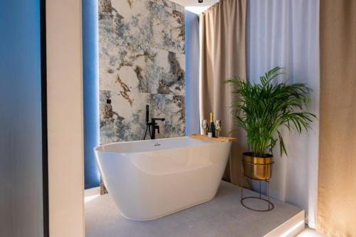a bathroom with a white tub and a plant at Samstag ParkZone in Split