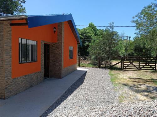 un bâtiment orange avec une porte et une clôture dans l'établissement Cábañas cielos Del jaure, à Jaureguiberry