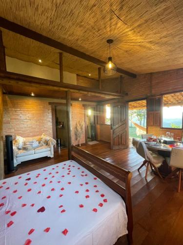 una camera da letto con un letto con rose rosse sopra di Chalé Mirante da Serra a Sabará