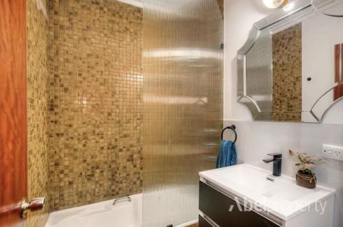 Un baño con lavabo y ducha en Tranquil home in hills with city views, en Greenmount