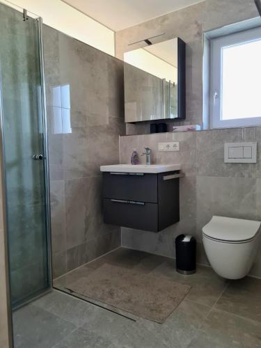 a bathroom with a toilet and a sink and a shower at Ferienwohnung Lösel in Freilassing