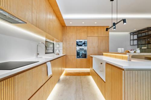 a kitchen with white countertops and wooden cabinets at Villa Toscana by Madeira Dream Stays in Funchal