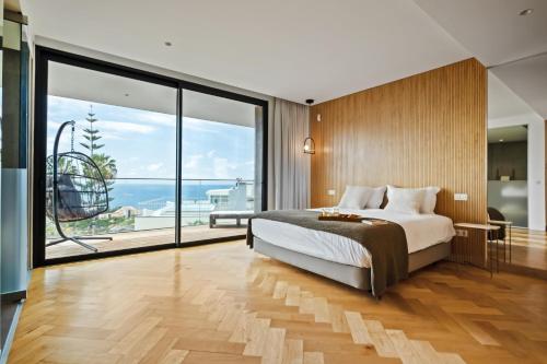 a bedroom with a large bed and a large window at Villa Toscana by Madeira Dream Stays in Funchal