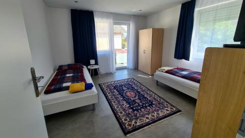 a small room with two beds and a rug at Ferienwohnung Lösel in Freilassing