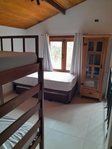 a bedroom with two bunk beds and a window at Chalé Colibri in Vale do Capao