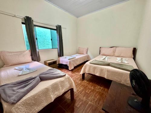 une chambre avec deux lits et une fenêtre dans l'établissement Casa da Rany, à Sao Jorge