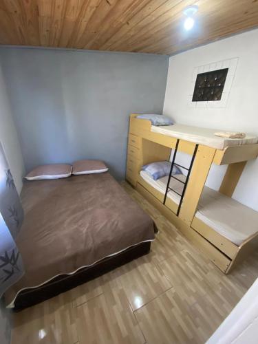 a room with two bunk beds and a desk at Casa em Coroados - 800 metros da praia in Guaratuba