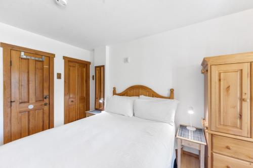 a bedroom with a large white bed and wooden cabinets at Red Hawk Lodge #2213 in Keystone