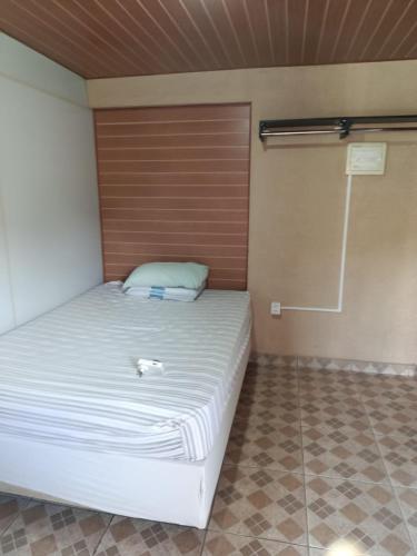 a bedroom with a bed with a wooden door at Chalé da Vovó Neusa in Socorro