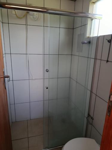a bathroom with a glass shower with a toilet at Chalé da Vovó Neusa in Socorro