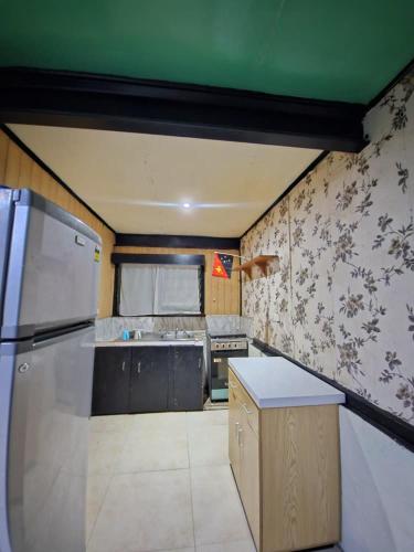 a kitchen with a refrigerator and a stove at HeightsVille Transit in Port Moresby