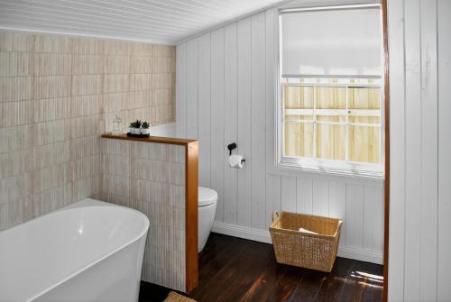une salle de bain avec baignoire et toilettes et une fenêtre dans l'établissement Cedar Cottage Daylesford, à Daylesford