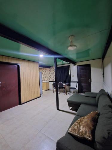 a living room with green ceilings and a couch at HeightsVille Transit in Port Moresby