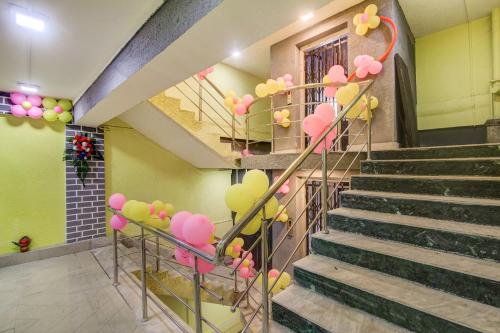 a staircase with pink and yellow balloons on the stairs at Capital O Divira Inn in Dhanbād