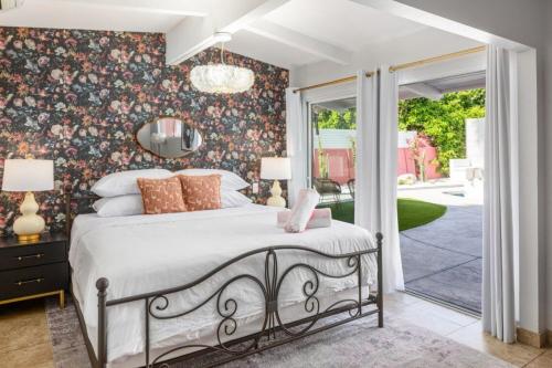 a bedroom with a bed with a floral wallpaper at The Muse Hotel Palm Springs in Palm Springs